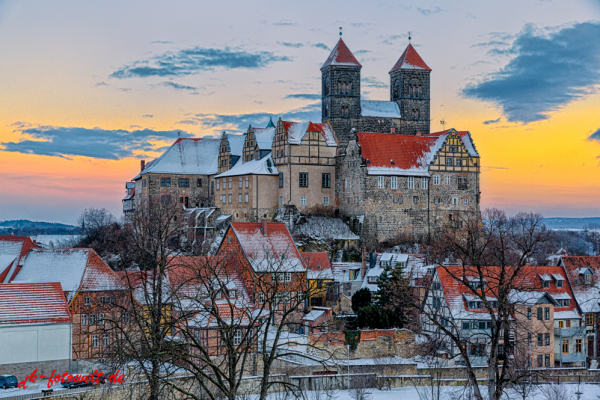 Das Quedlinburger Schloss und Stiftskirche im Winter beim Sonnenuntergang