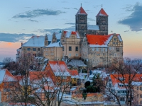 Das Quedlinburger Schloss und Stiftskirche im Winter beim Sonnenuntergang