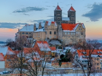 Das Quedlinburger Schloss und Stiftskirche im Winter beim Sonnenuntergang